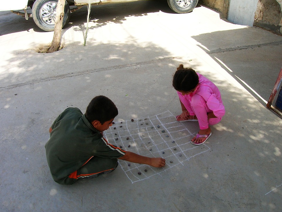 Dvě děti, malovaná hra křídou s kamínky